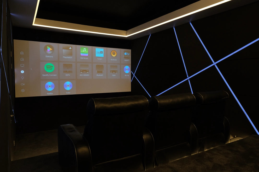 A dedicated Smart Spaces cinema room with tiered seating, projection screen, concealed speakers and acoustic wall panels